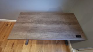 The grey wooden inspired top of the Friska Stockholm standing desk