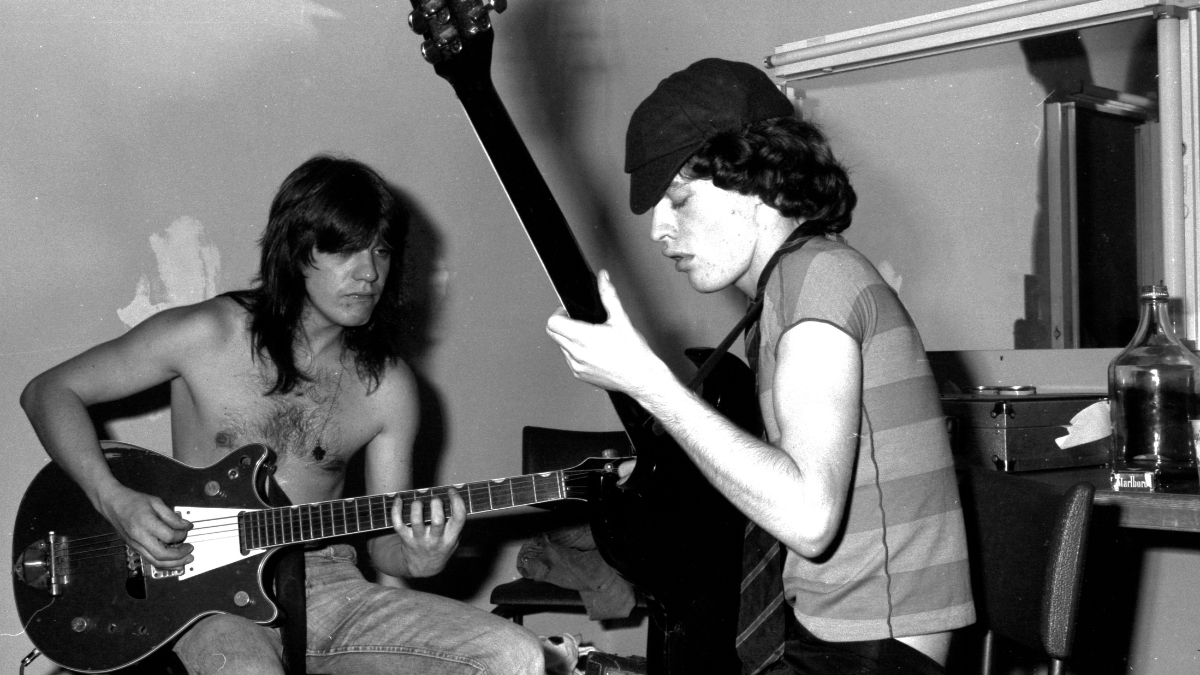 Malcolm Young and Angus Young of AC/DC, playing guitars backstage at the Hordern Pavilion, Sydney, Australia, 12th December 1976