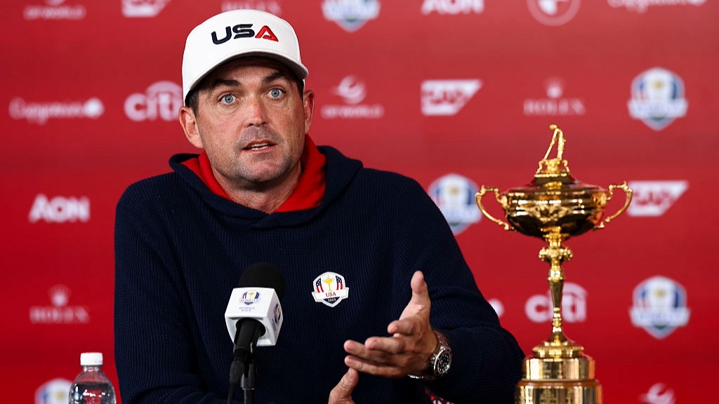 USA Ryder Cup captain Keegan Bradley answers a question in a press conference, next to the trophy