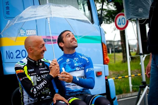Fortunato Baliani (Team NIPPO) and Maximiliano Richeze (Team NIPPO) under an umbrella