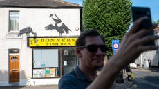 An admirer takes a selfie outside a Banksy mural on the wall of Bonners fish and chip shop in Walthamstow, North London