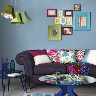 living room with blue walls sofasets and photoframe on wall