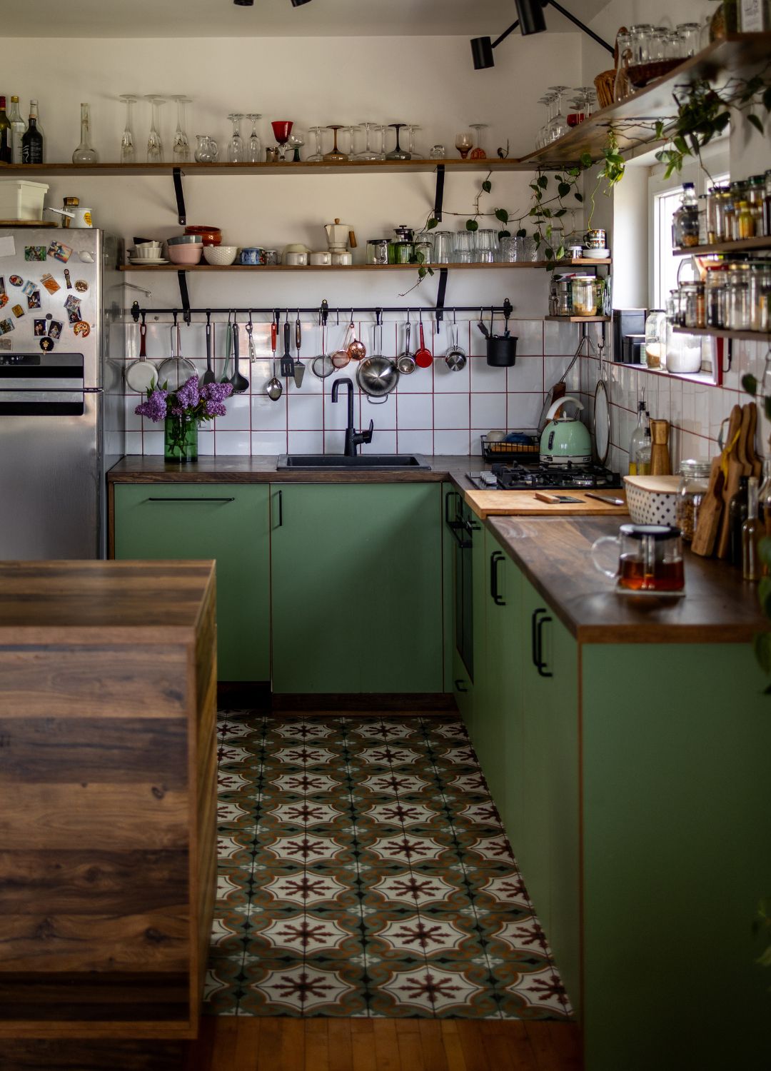 picture of green kitchen with patterned tile floor and eclectic decor