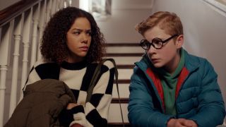 Ginny and Austin sitting on the steps of their home in Ginny & Georgia Season 3. 