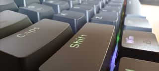 A grey Sablute SG KM61 keyboard sitting on a wooden desk