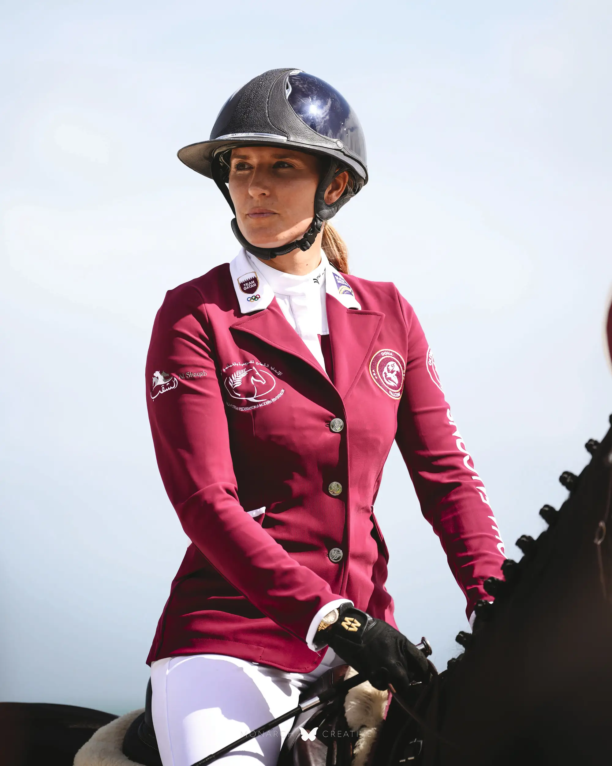 Close up of Jess Mendoza sitting on a horse in a burgundy show jacket