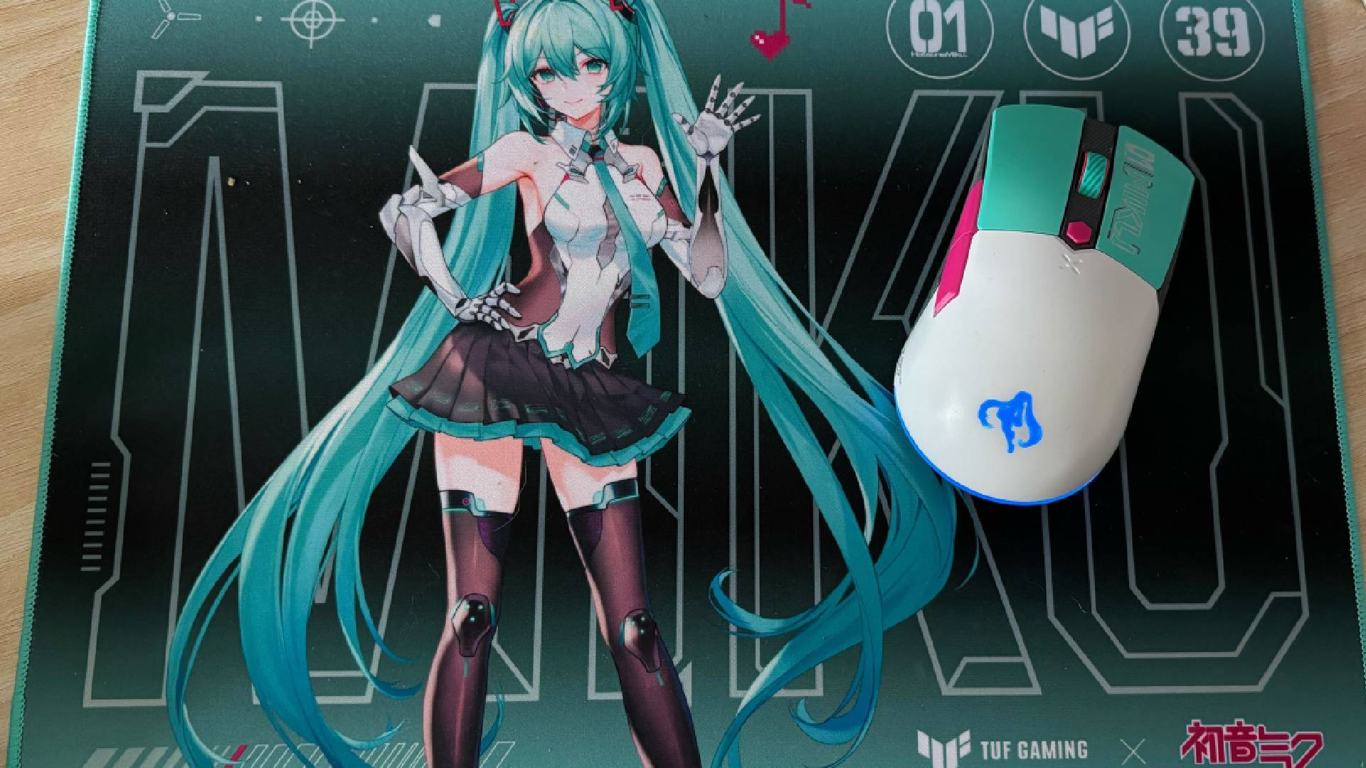 Miku x TUF Gaming Mouse on Mousemat against pale wood background
