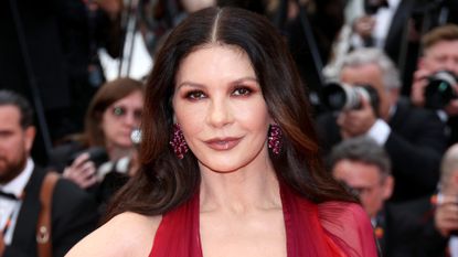Catherine Zeta-Jones wears a red dress as she attends the "Jeanne du Barry" Screening & opening ceremony red carpet at the 76th annual Cannes film festival at Palais des Festivals on May 16, 2023 in Cannes, France