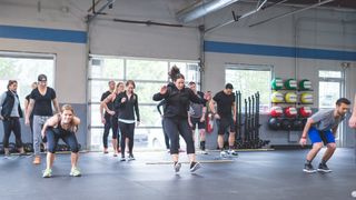 People perform two-footed jumps indoors