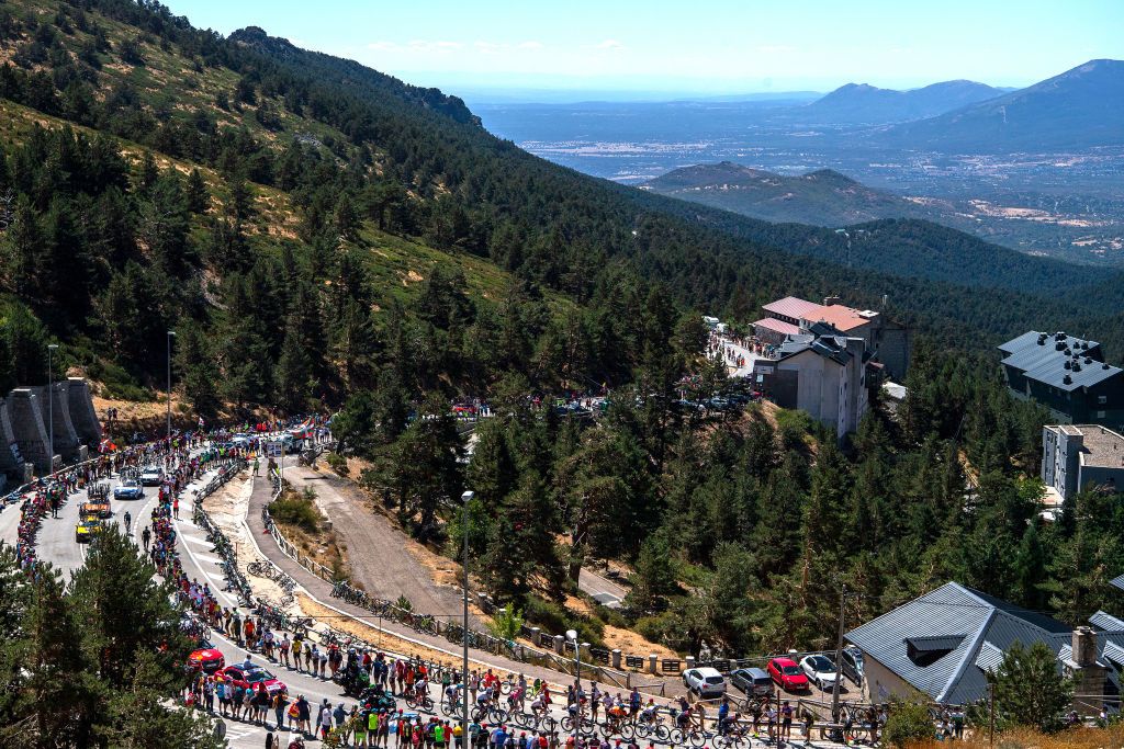 NAVACERRADA SPAIN SEPTEMBER 10 A general view of the peloton passing through the Puerto de Navacerrada 1851m while fans cheer during the 77th Tour of Spain 2022 Stage 20 a 181km stage from Moralzarzal to Puerto de Navacerrada 1851m LaVuelta22 WorldTour on September 10 2022 in Puerto de Navacerrada Spain Photo by Justin SetterfieldGetty Images