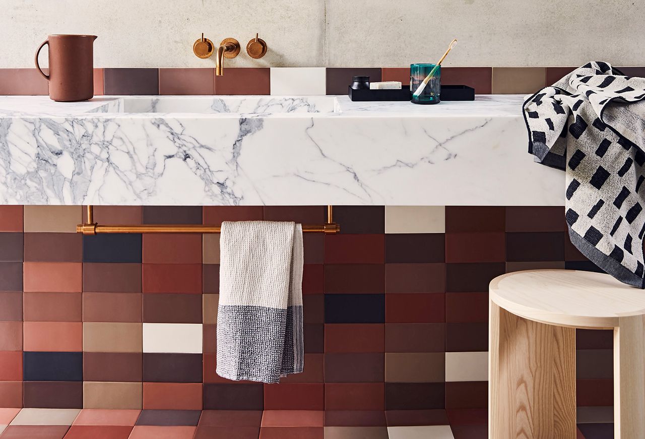 modern red and grey bathroom with a gold towel rail