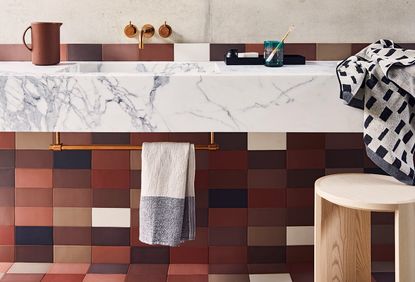 modern red and grey bathroom with a gold towel rail