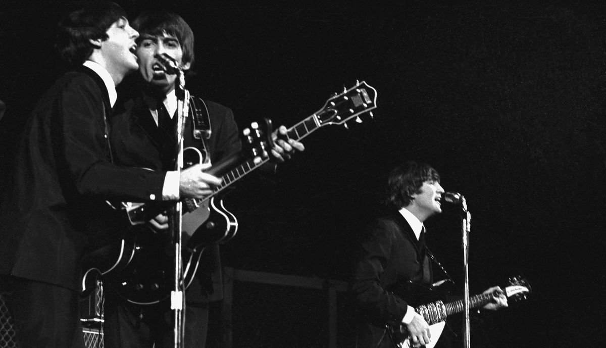 (from left) Paul McCartney, George Harrison and John Lennon perform onstage on August 1, 1964