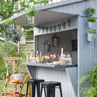 garden bar with bar stools and hanging plants