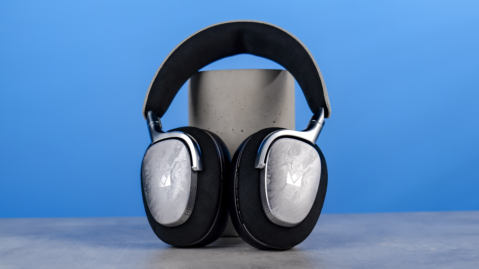 The Noble Audio FoKus Artemis on a stone surface, propped up on a plinth, against a blue background