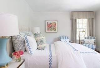 bedroom with blue and white linen and pastel cushions