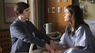 Freddie Highmore holds Paige Spara's hand in a hospital bed in The Good Doctor