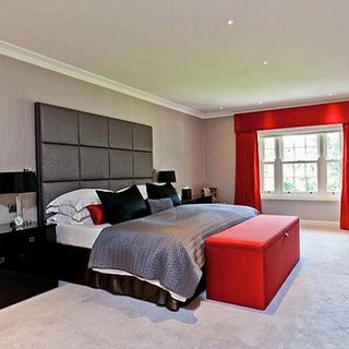 bedroom with headboard on bed and carpet flooring
