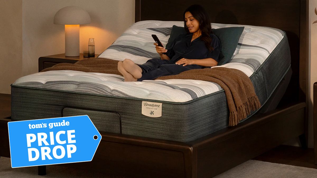 Beautyrest Black with an adjustable base, now discounted in the Presidents&#039; Day mattress sales. Image features a woman with her adjustable mattress + base at a slight incline, using a remote control to adjust her comfort.