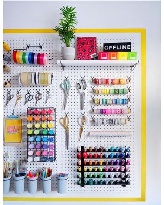 A pegboard with colorful craft items and accessories on it