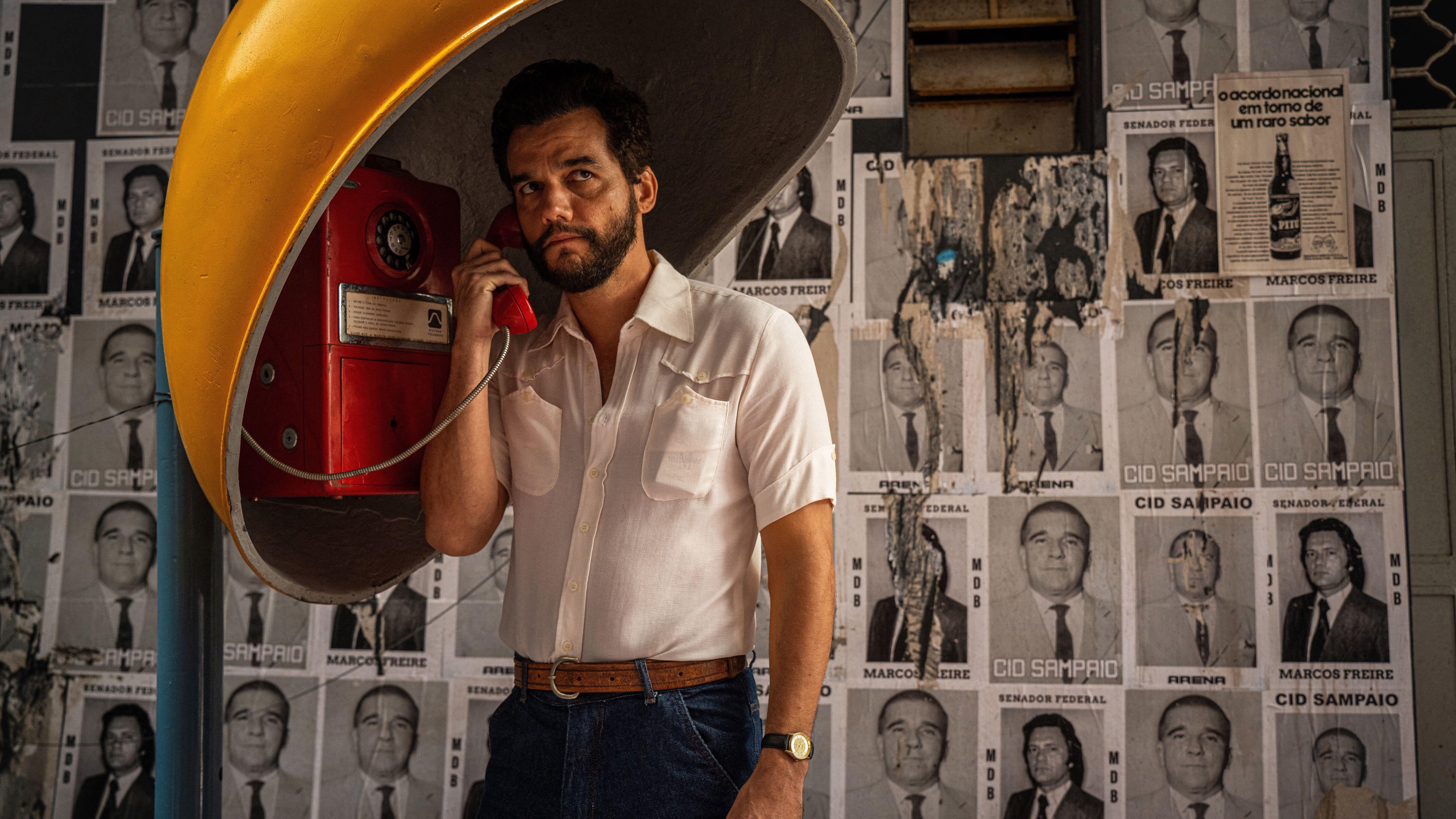 Wagner Moura using a payphone in a promotional still for "The Secret Agent"