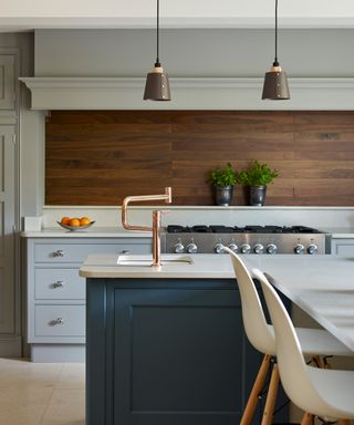 Wood-effect kitchen tile ideas in a pale gray kitchen with pendant lighting and a white breakfast bar.