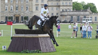 Harry Meade and Cavalier Crystal jump a cross-country fence in front of Badminton House in 2025.