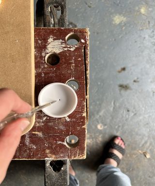Awl making a hole in a plastic lid