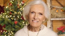 Dame Mary Berry smiles in front of a Christmas tree in an announcement for A Mary Berry Christmas