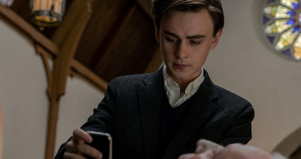 Mr. Harrigan&#039;s Phone star Jaeden Martell holding a cellphone at a funeral