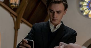 Mr. Harrigan's Phone star Jaeden Martell holding a cellphone at a funeral