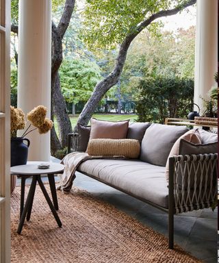 Patio with an outdoor sofa styled with accessories in natural materials