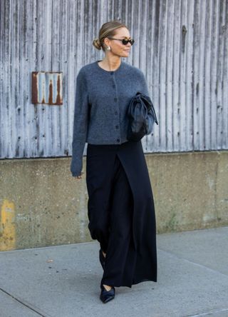 Claire Rose Cliteur wearing a grey cardigan and long black skirt.