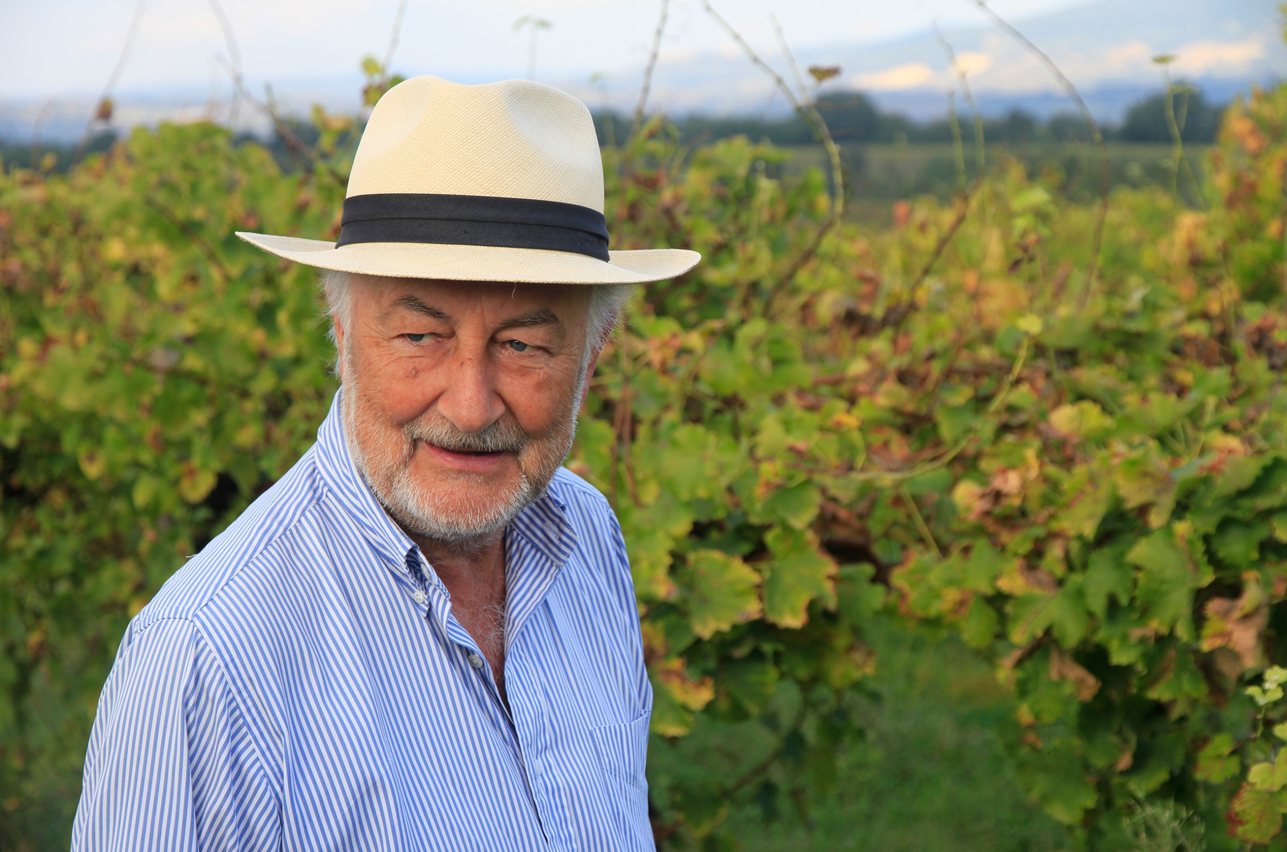 Close-up shot of Sergio Mottura, standing in front of vines
