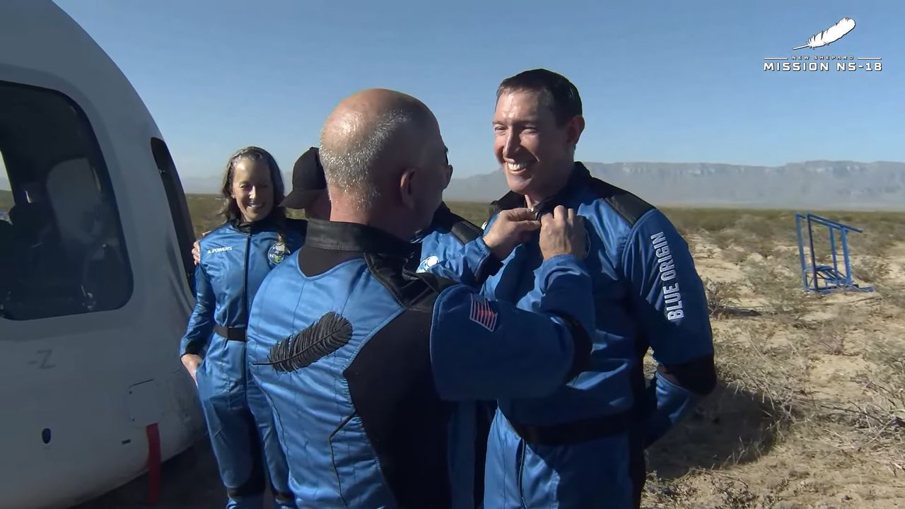 Jeff Bezos pins astronaut wings on Glen de Vries after the Blue Origin NS-18 mission, on Oct. 13, 2021.