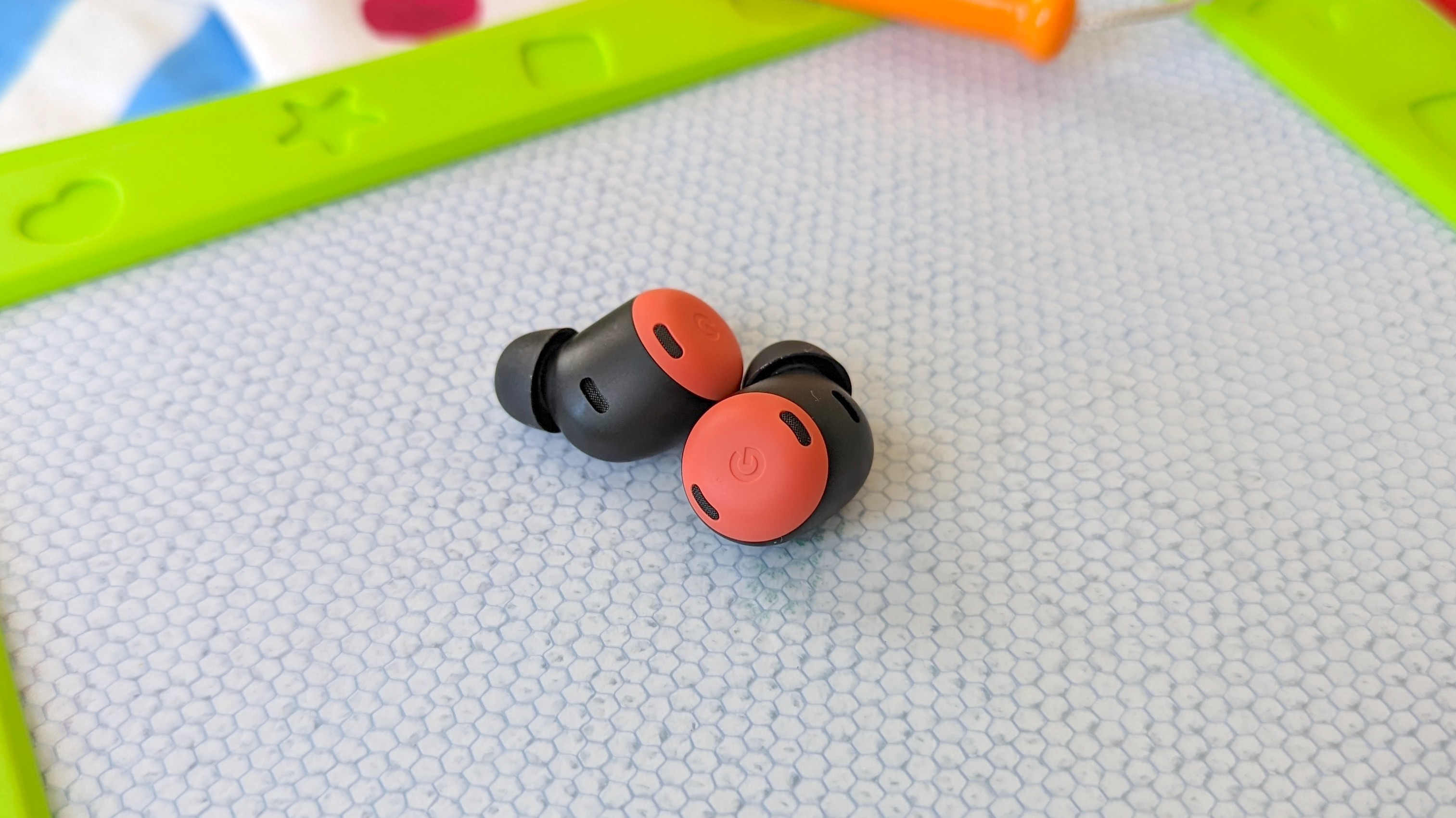 The Google Pixel Buds Pro wireless earbuds resting on an Etch-a-Sketch