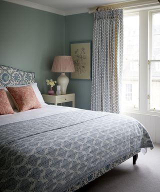 bedroom with blue walls and patterned headboard and bedspread in Edinburgh Georgian townhouse designed by Jessica Buckley