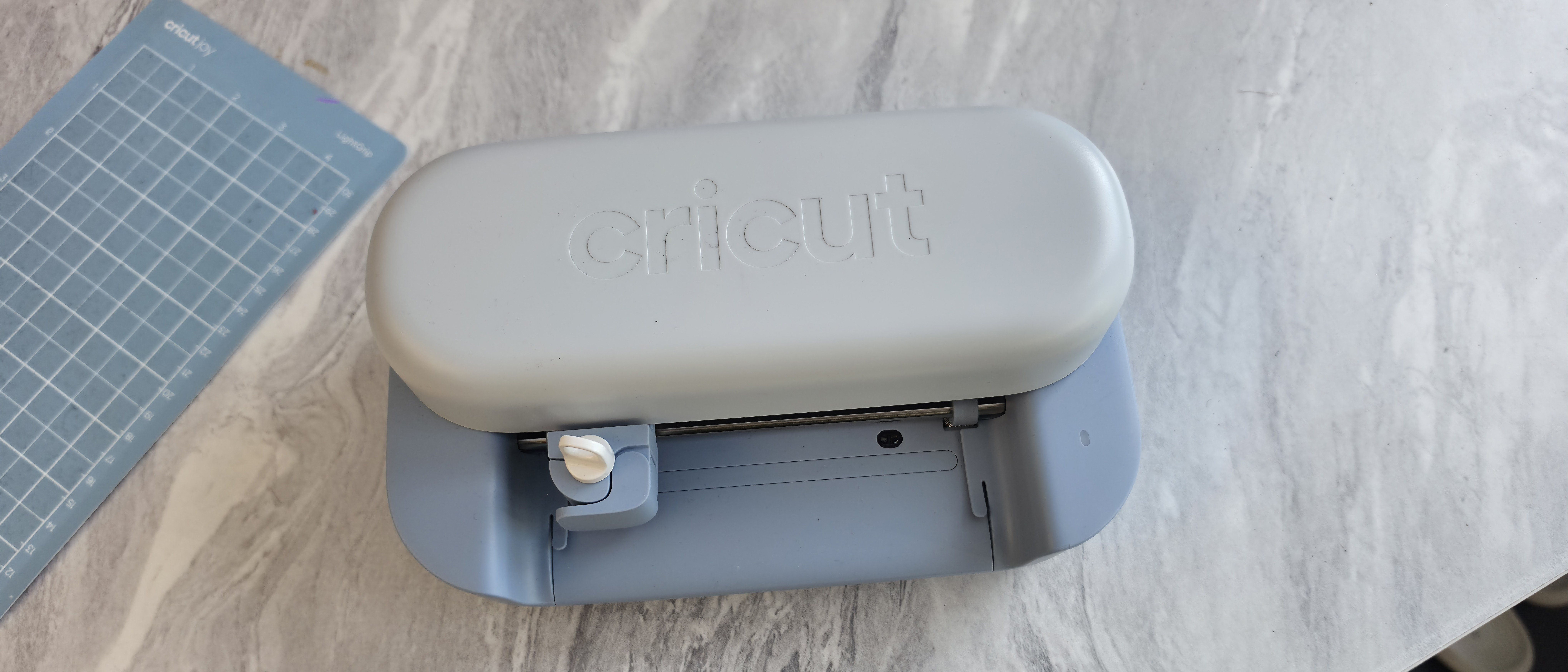 The Cricut Joy 2 on a white marble craft table