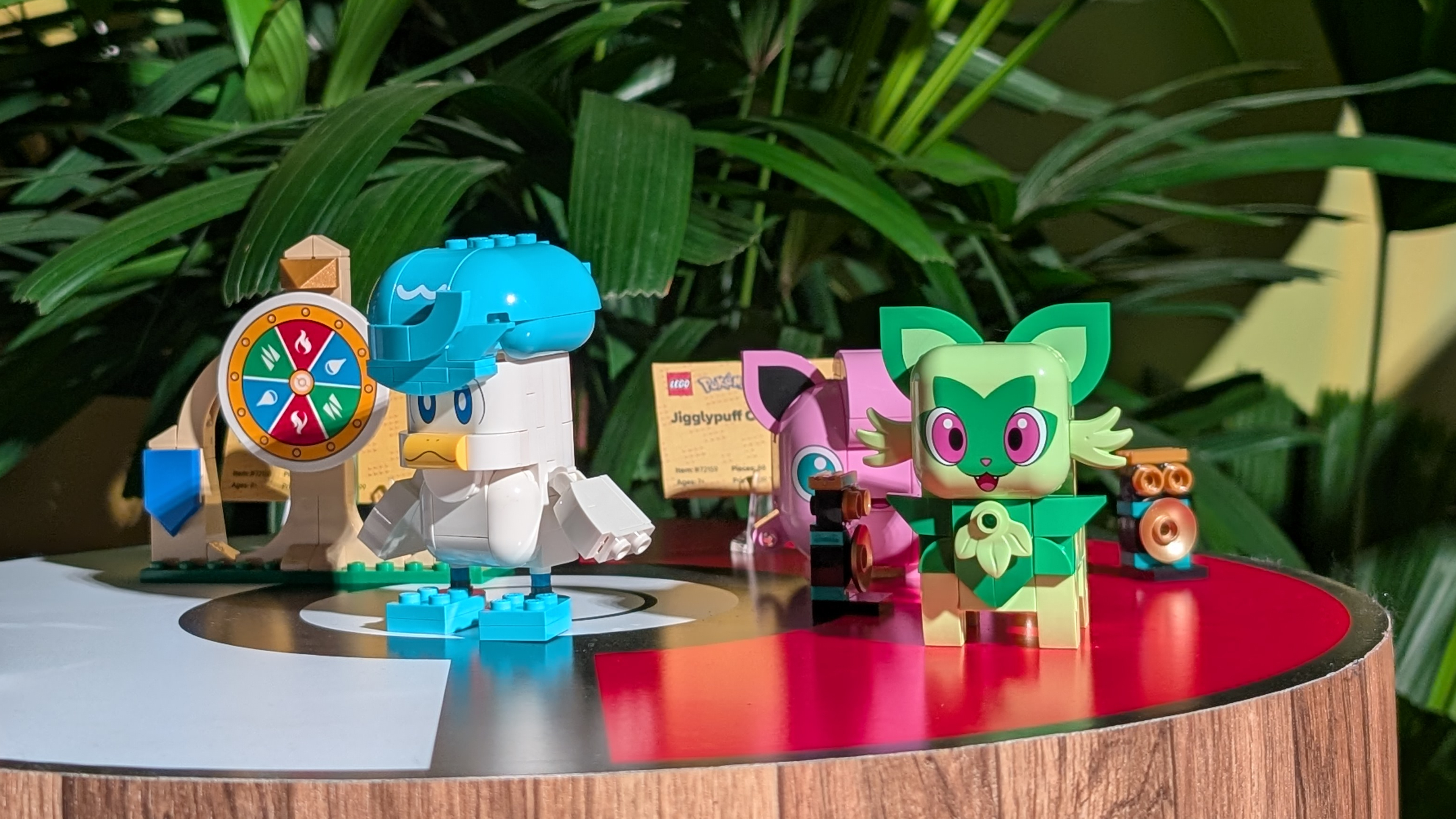 Lego Pokemon laid out on a red and white Poke Ball surface, with leaves visible in the background