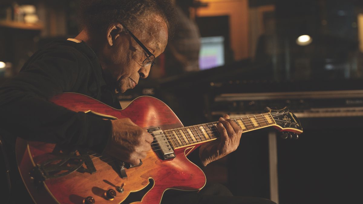 Portrait-style shot of jazz guitarist George Freeman playing guitar in a recording studio