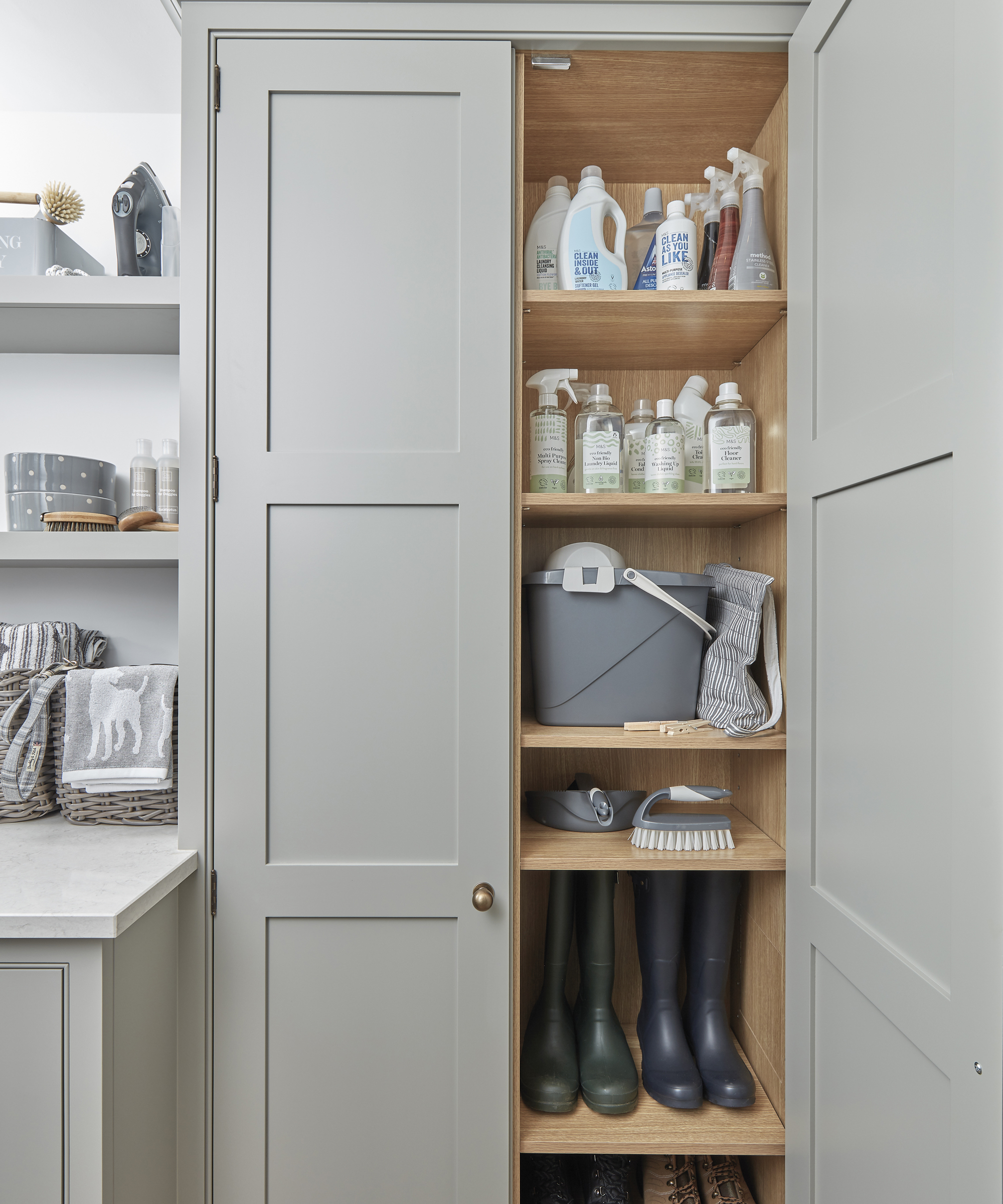 A small utility room idea with tall cabinet opened to show organised shelves