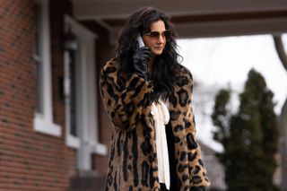 poorna jagannathan as lucky wearing a leopard print coat on the phone in a still from deli boys