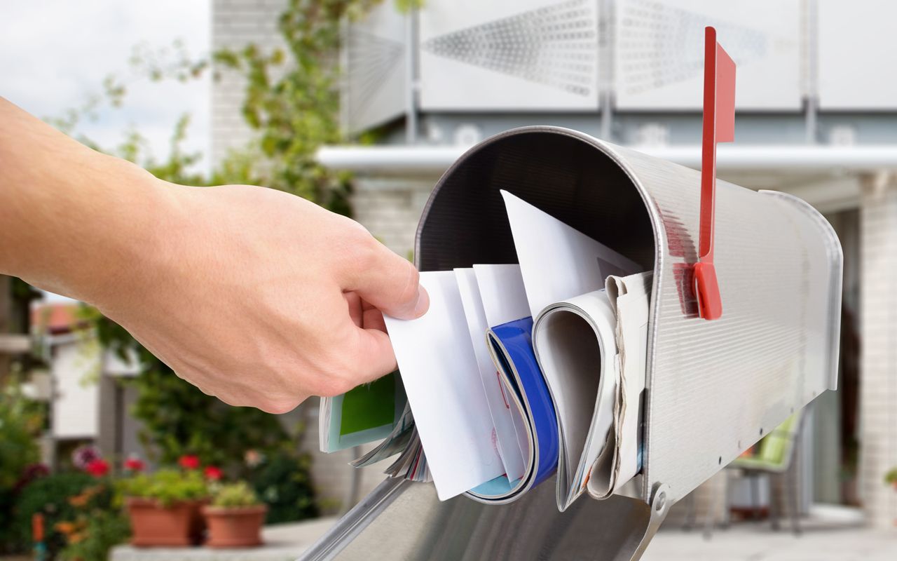 Close-up Of Man&amp;#039;s Hand Taking Letter From Mailbox Outside House