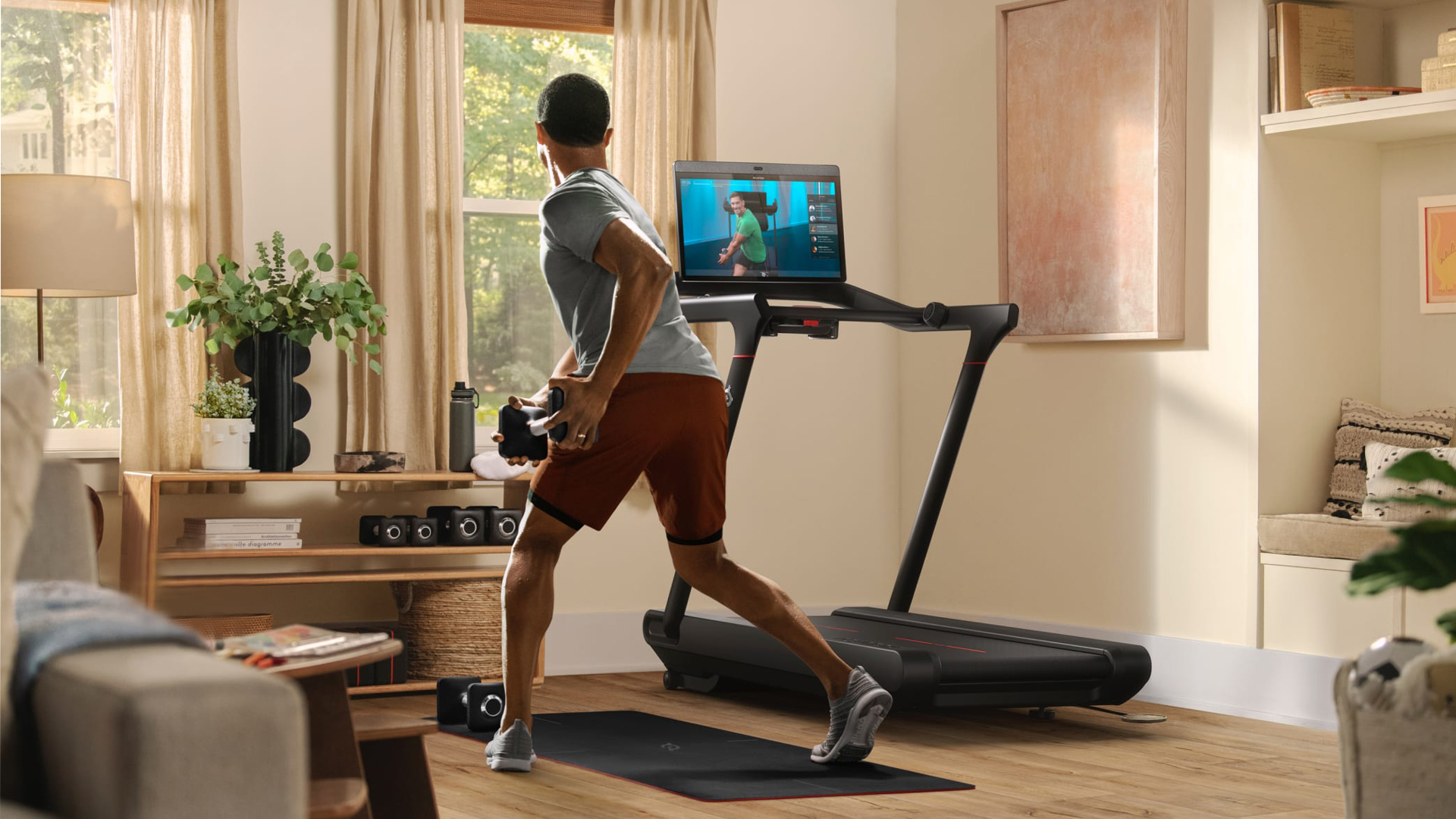 Man doing exercises beside Peloton Tread treadmill