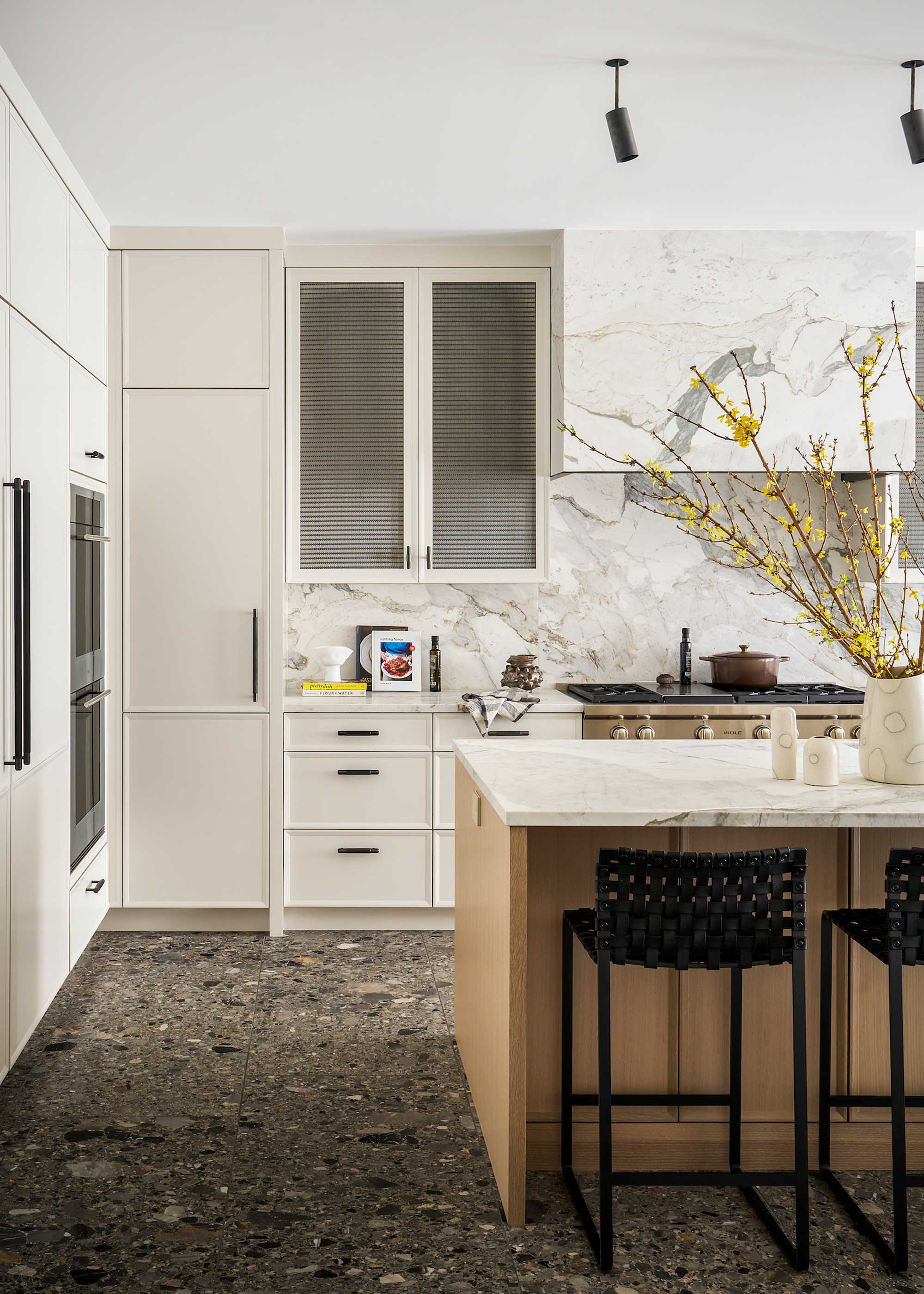 white kitchen with marble splashback and terrazzo flooring
