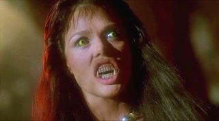 a girl with fangs and yellow eyes showing off her teeth in 'The Howling'