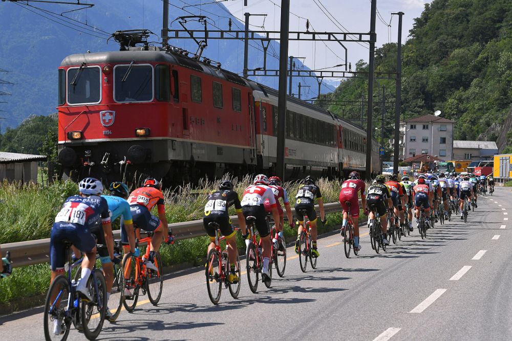 A train passes the peloton during stage 8 at Tour de Suisse