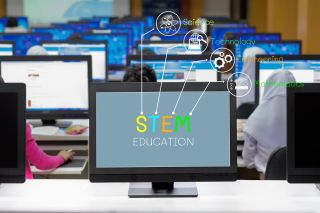 The phrase STEM Education appears on desktop computer monitor, with icons representing Science, Technology, Engineering and Math
