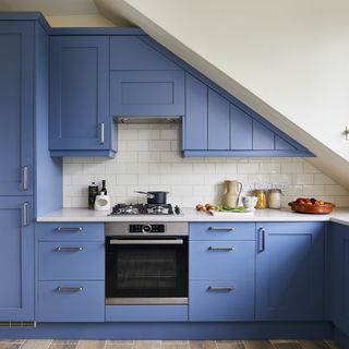 small blue Shaker style kitchen with metro tiles