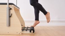 Man balancing on pilates chair in exercise room